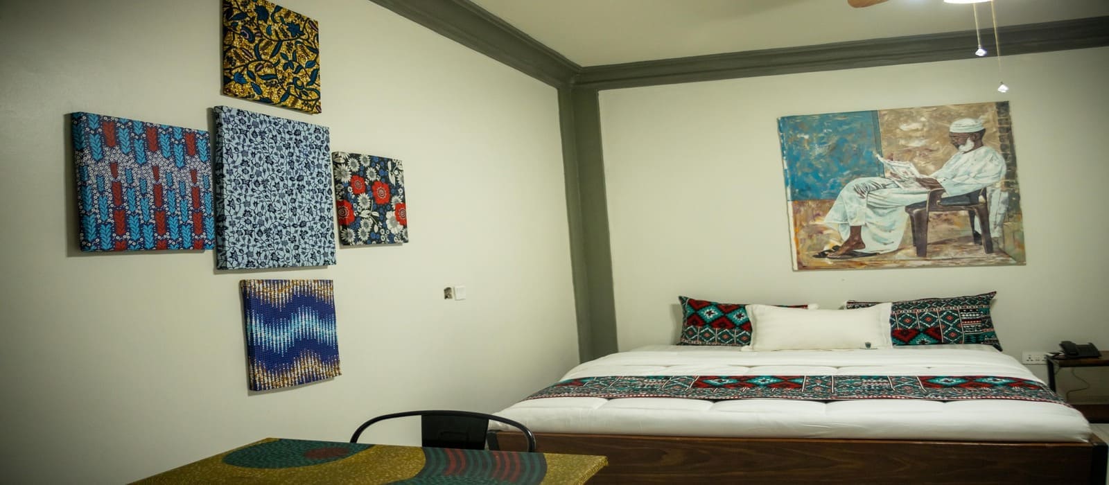 Spacious guest room at Heritage Hotels Arua featuring local art and vibrant African textiles