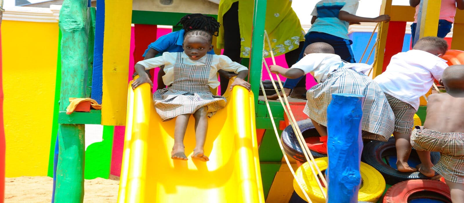 Children playing on a colorful slide at Heritage Hotels Arua's kids’ park