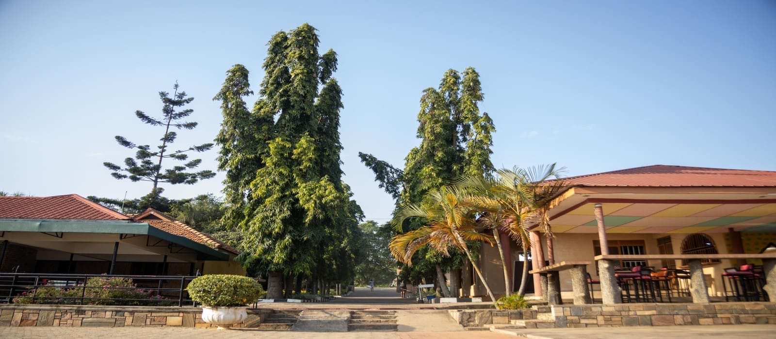 Exterior of Heritage Hotels Arua showcasing landscaped grounds and outdoor seating area