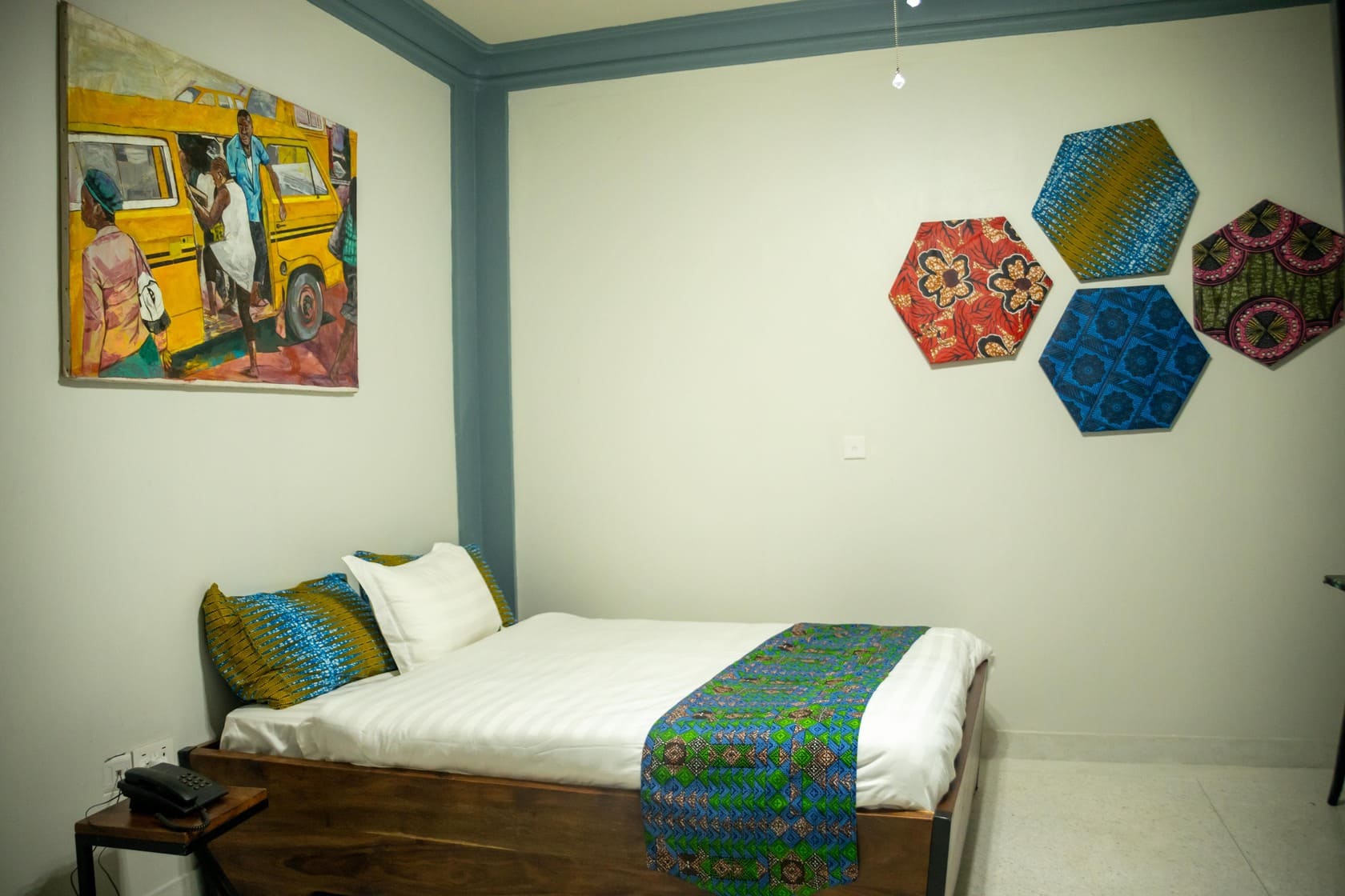 Cozy guest room with comfortable bed decorated with local art work.