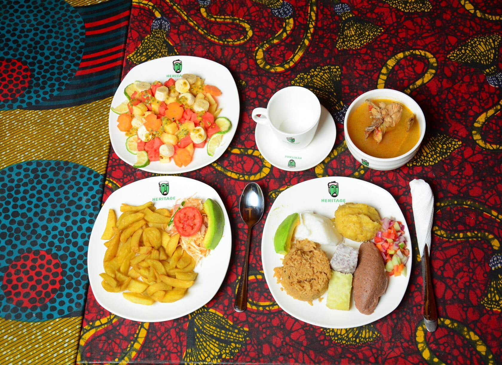A meal with chips, fruits, and beef served on a large plate.